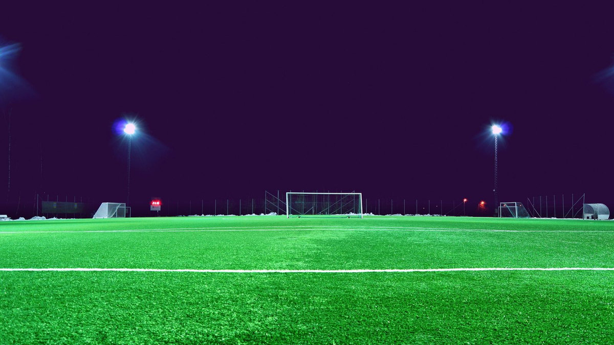 Stade de football vide la nuit, pelouse éclairée