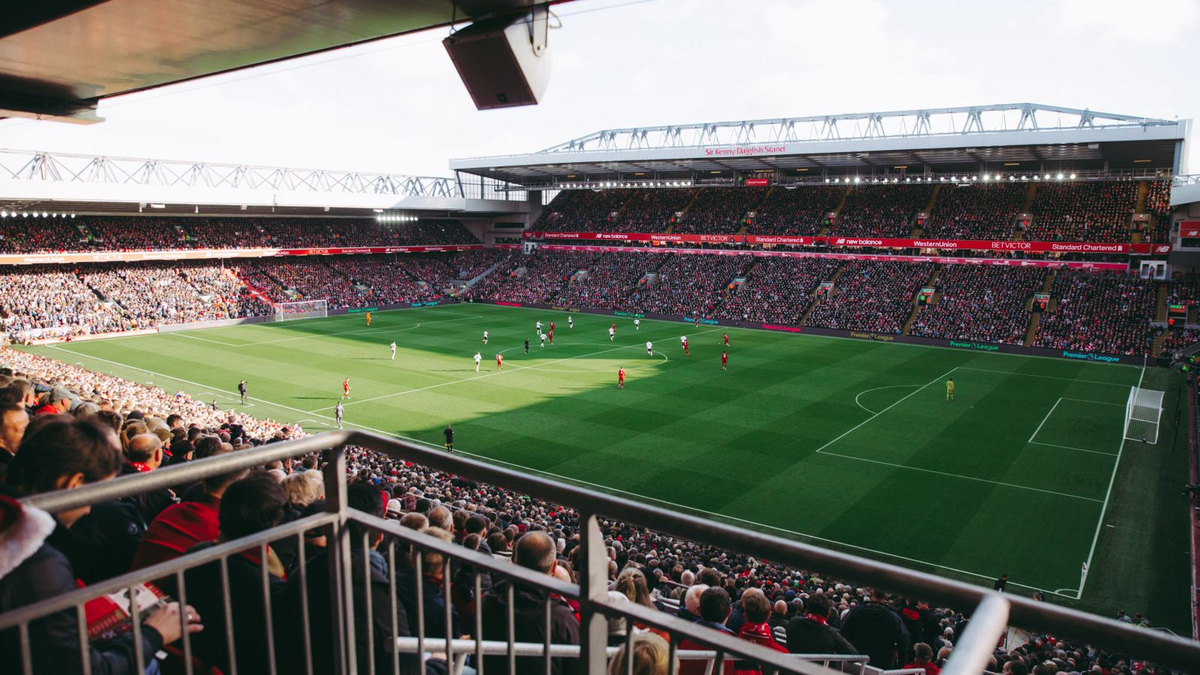Stade de football plein le soir, pelouse éclairée