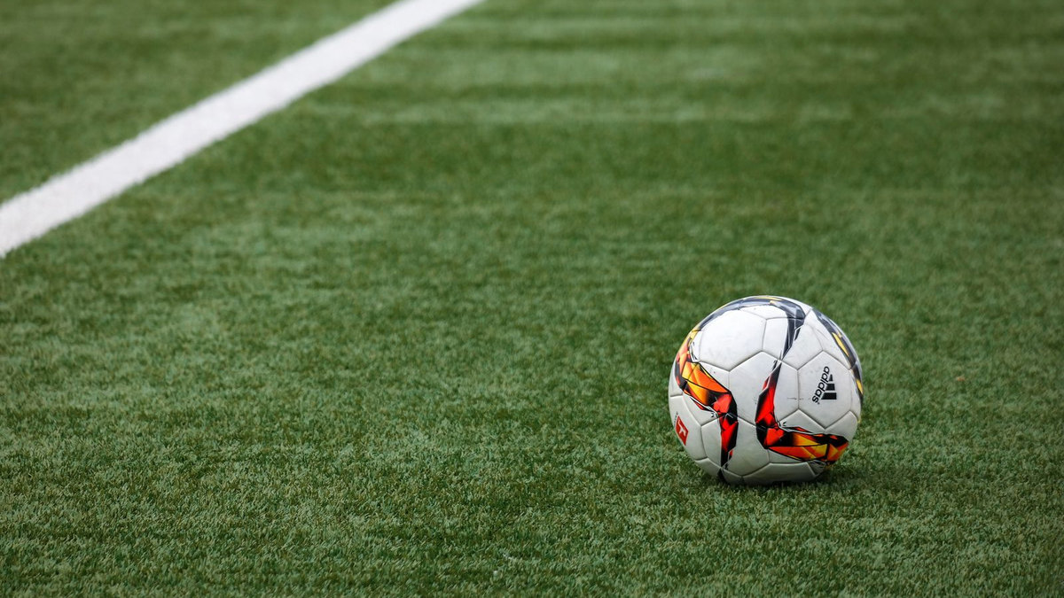 Match de football en cours sous les projecteurs d’un stade