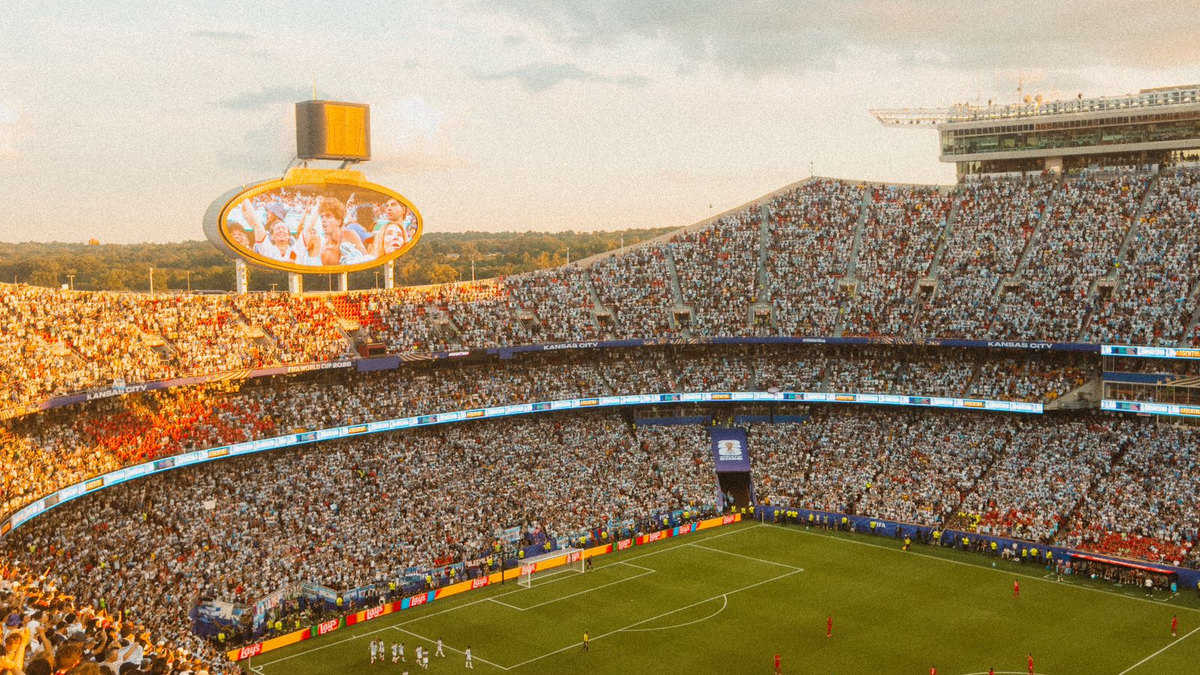 Grand stade de football plein au coucher du soleil